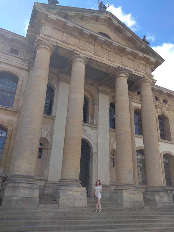 Me stood in front of Claredon Building with big columns.
